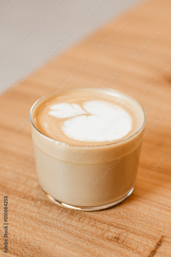 Beautiful stylish cappuccino in a glass cup on the table. Creative coffee serving Beautiful stylish cappuccino in a glass cup on the table. Creative coffee serving