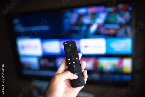 Rio de Janeiro / Brazil- February 3, 2021: amazon fire tv stick remote in hand with selective focus tv background. During the COVID-19 lockout. photo