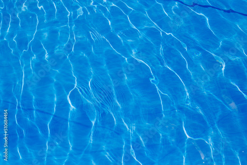Beautiful blue water pattern. The sun is shining in the pool. Lovely tropical getaway and relax. Style water texture