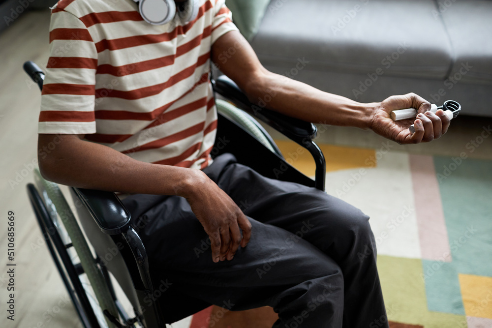 Obraz premium Closeup of man with disability exercising hand and arm muscles by using hand expander