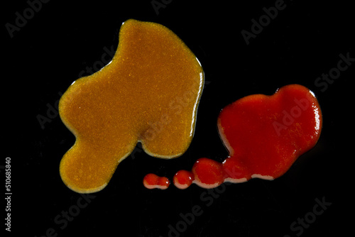 Drops of different sauces on black table