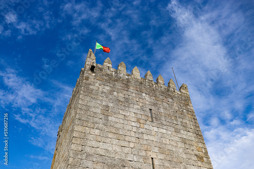 Tower of Guimaraes Castle with portuguese flag, Guimaraes, Portugal. photo