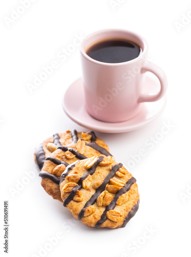 Chip cookies with peanuts and chocolate strips and coffee cup isolated on white background.