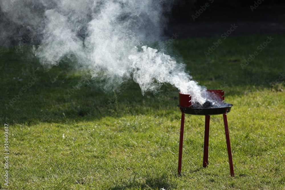 Grill anfeuern mit viel Rauch im Park