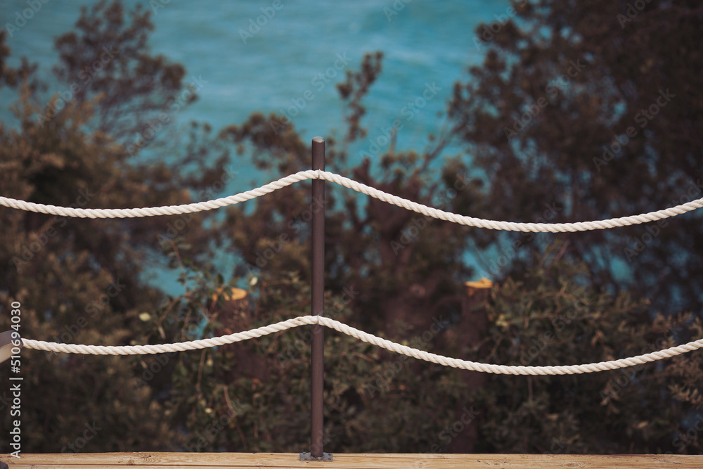 Marine motifs. Rope railing by the sea. Banister railing on marine rope and wood Italy, Mediterranean sea. Marine motifs. Rope railing by the sea. Banister railing on marine rope and wood Italy, Mediterranean sea.