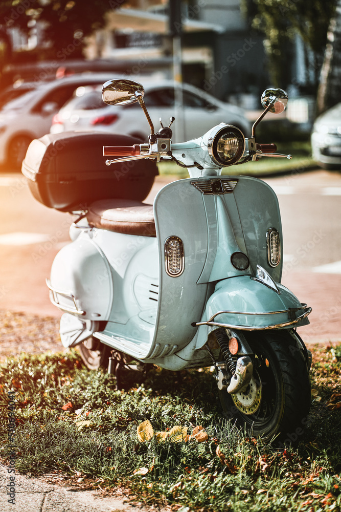 alcanzar Hermana pasta A vintage light blue scooter of retro style stands near an alley.  Carsharing electric moped on a European streets foto de Stock | Adobe Stock