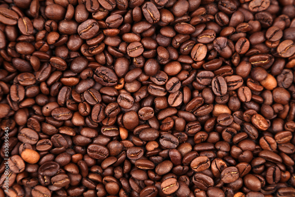 Fototapeta premium Close-up of roasted brown coffee beans background 