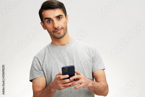Cheerful man in a gray t-shirt with a phone communication technology cropped view © SHOTPRIME STUDIO