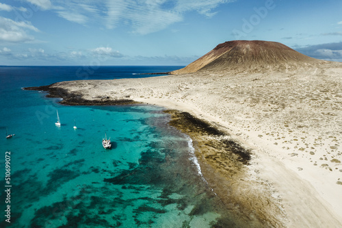 Vista aerea de playa en la isla de la graciosa islas canarias con mar turquesa y barcos photo