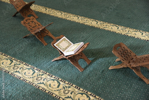 The Holy Qur’an on a wooden stand in the mosque, prayer and supplication in the mosque, worship and getting closer to God