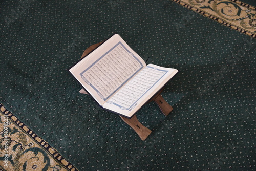 The Holy Qur’an on a wooden stand in the mosque, prayer and supplication in the mosque, worship and getting closer to God