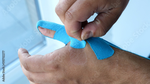 Man taking kinesiology tape off his thumb