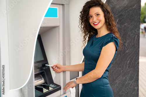 Charming curly hair girl at ATM