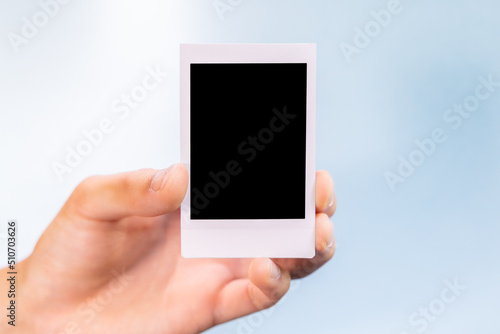 Hand holding a blank disposable polaroid photo graphic resource