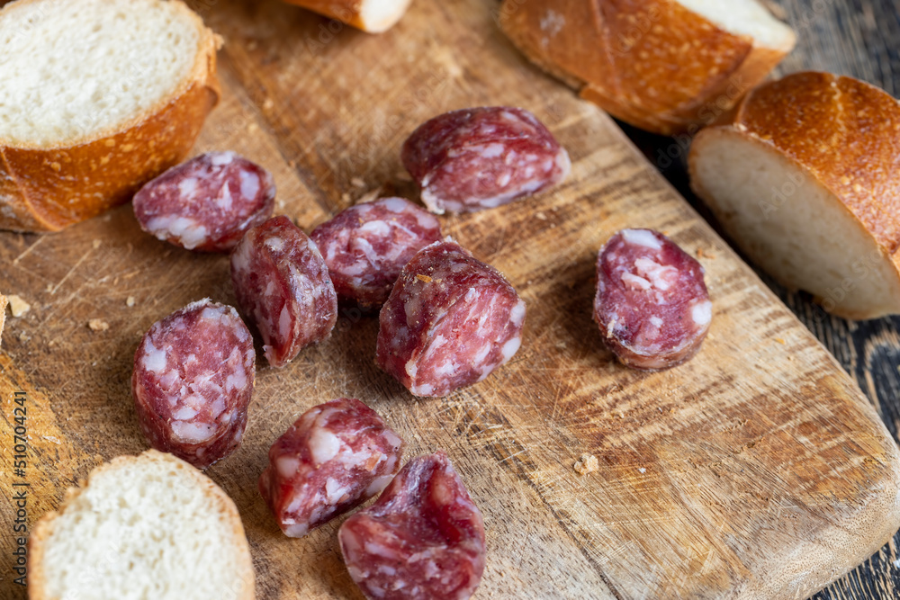 sausage sliced with a baguette on a wooden board sausage sliced with a baguette on a wooden board