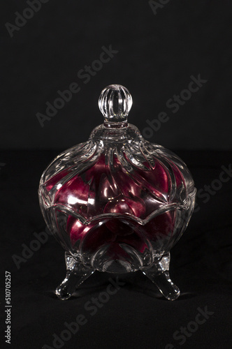 plums inside a glass container with black background