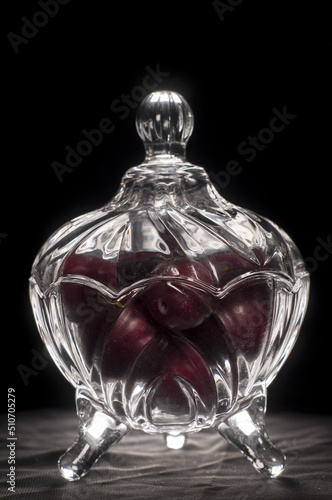 plums inside a glass container with black background