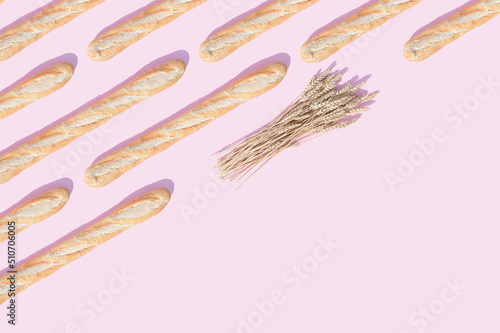 Pattern made of bread and wheat on a pink background. Diagonal copy space.