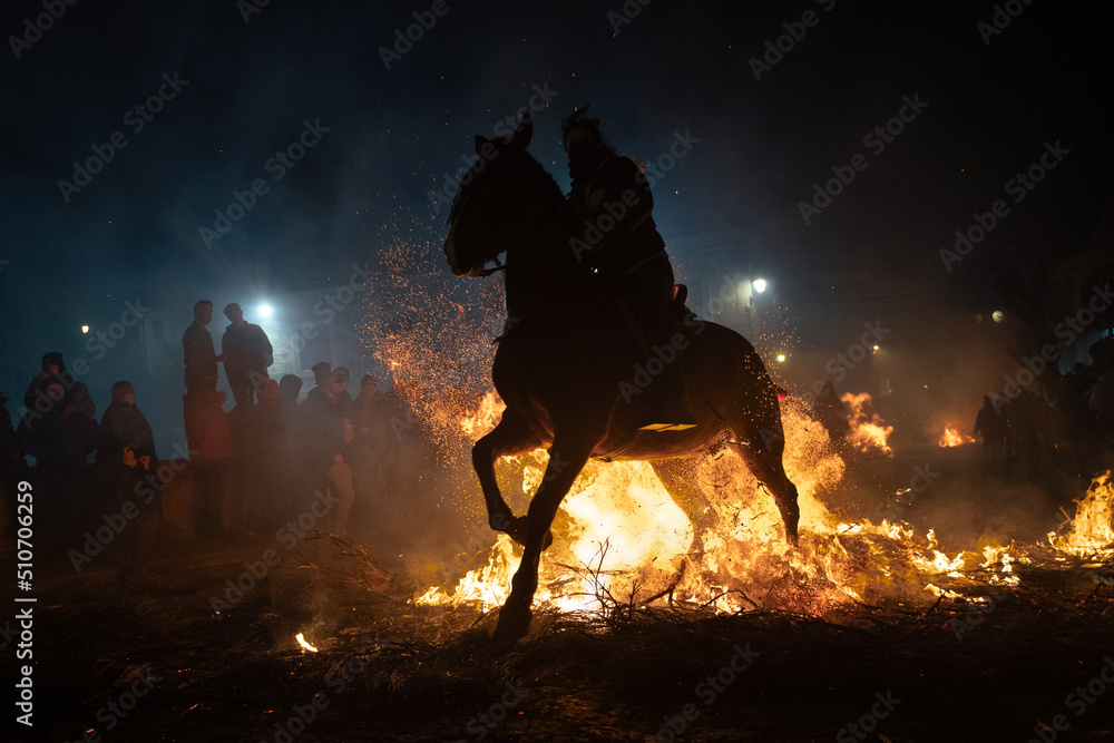 Fototapeta premium horses with their riders jumping bonfires as a tradition to purify animals..