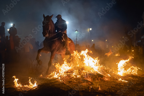 horses with their riders jumping bonfires as a tradition to purify animals Fototapet