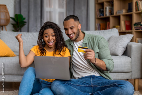 Yes, huge sales in webstore. Happy black couple shopping online, holding credit card and using laptop at home