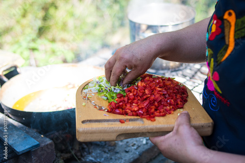 Farmer woman cooking outdoors in nature happily