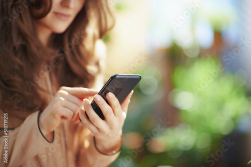 Elegant woman at home in sunny day using phone applications photo
