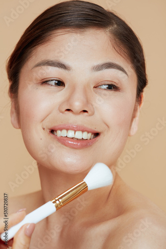 young asian woman with makeup brush