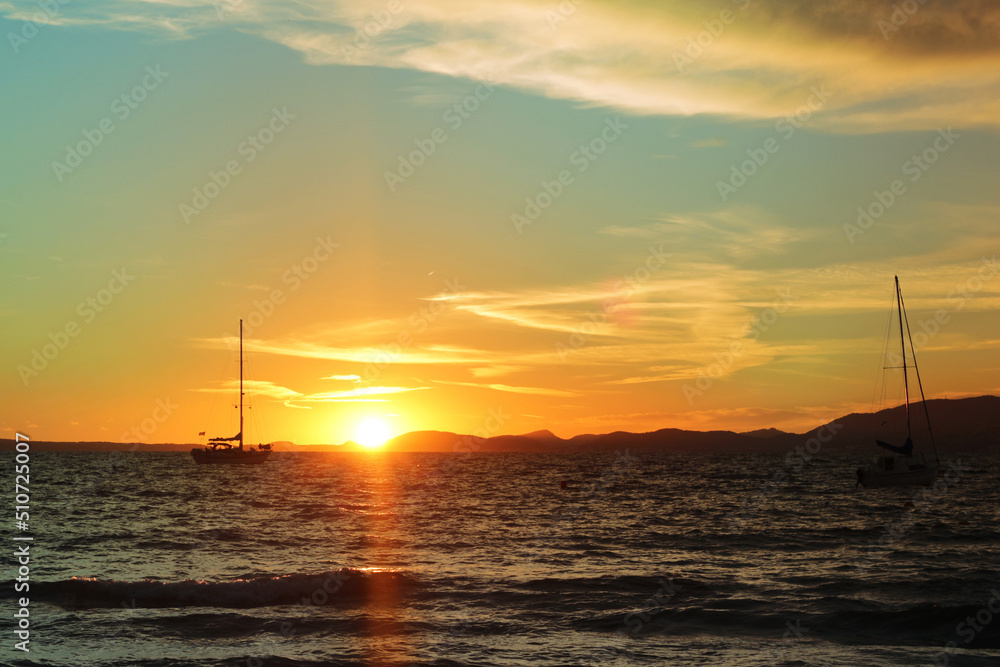 Fiery sunset on the coast. Relax atmosphere. View of the sunset on the sea, El Arenal, Mallorca. Bright saturated sunset on the sea and a rocking boat on the waves, Mallorca, Spain. Fiery sunset on the coast. Relax atmosphere. View of the sunset on the sea, El Arenal, Mallorca. Bright saturated sunset on the sea and a rocking boat on the waves, Mallorca, Spain.