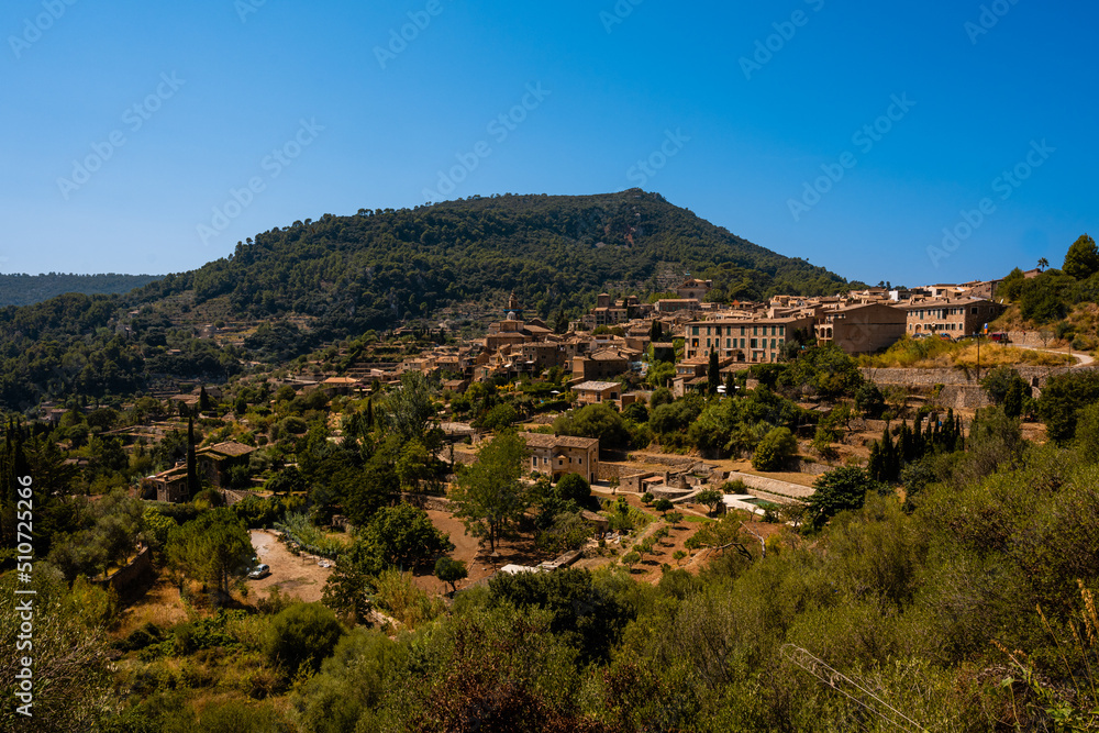 photography of the city of Valldemosa from the hillside above the road during a sunny afternoon on the island of Mallorca