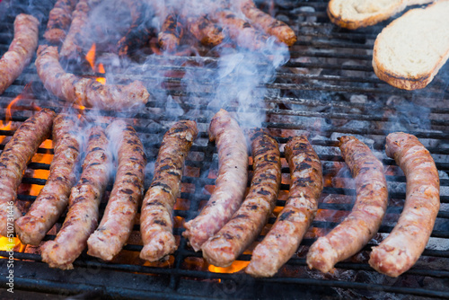 Delicious outdoor eating. Appetizing sausages grilling on portable bbq..