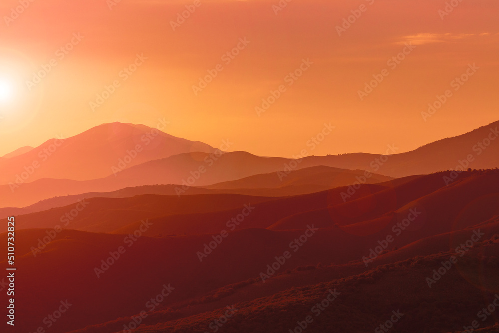 The sun rises over the mountain hills. Morning haze.