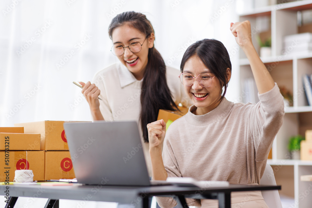 Two Young Asian women are happy and excited after a new order from SME customer, commercial checking, online marketing, Entrepreneur packing boxes, SME sellers, and freelance online sales concept, Two Young Asian women are happy and excited after a new order from SME customer, commercial checking, online marketing, Entrepreneur packing boxes, SME sellers, and freelance online sales concept,
