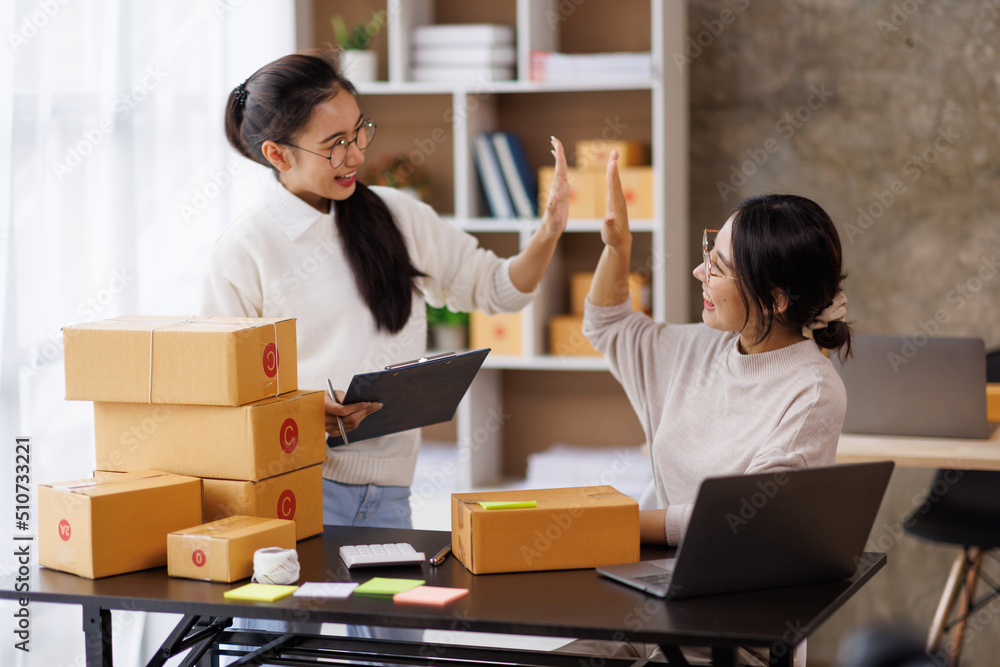 Two Young Asian women are happy and excited after a new order from SME customer, commercial checking, online marketing, Entrepreneur packing boxes, SME sellers, and freelance online sales concept, Two Young Asian women are happy and excited after a new order from SME customer, commercial checking, online marketing, Entrepreneur packing boxes, SME sellers, and freelance online sales concept,