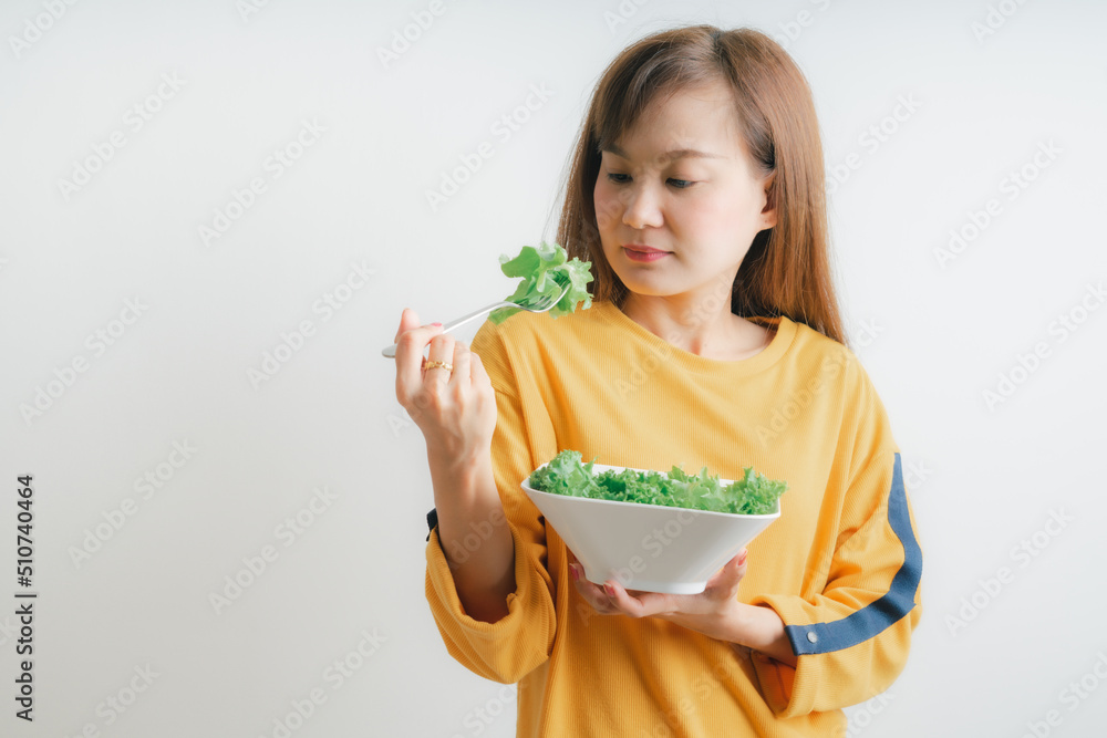 Asian woman eating a fresh salad isolated on white Asian woman eating a fresh salad isolated on white