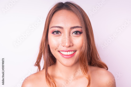 Beautiful and friendly young asian sexy female lady model wearing orange bikini posing happily with different poses  gestures and emotions against a clean and neat sweet pink pastel color background