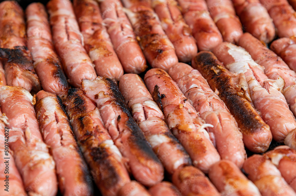 Sausages wrapped with bacon Roasted fat smoked and grilled over a bbq grill on the street food Sausages wrapped with bacon Roasted fat smoked and grilled over a bbq grill on the street food