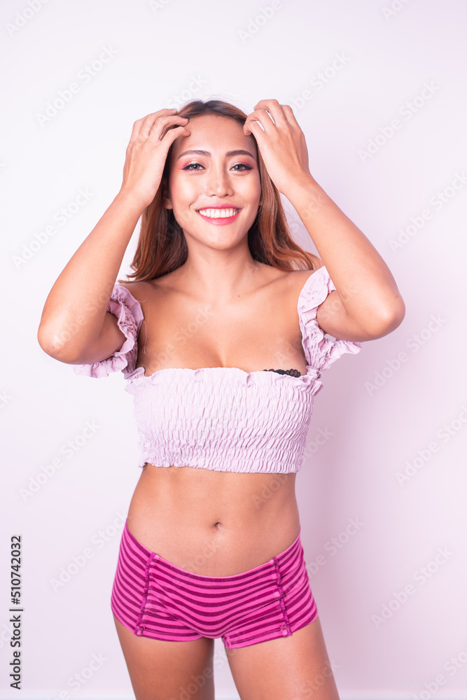 Beautiful and friendly young asian sexy female lady model wearing pink tops posing happily with different poses, gestures and emotions against a clean and neat sweet pink pastel color background Beautiful and friendly young asian sexy female lady model wearing pink tops posing happily with different poses, gestures and emotions against a clean and neat sweet pink pastel color background