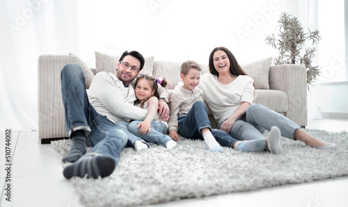 happy family sitting on the carpet in the living room.