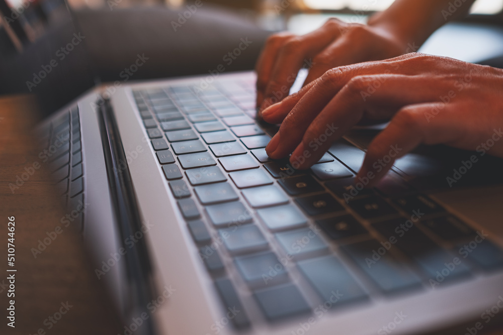 Closeup image of a woman working and typing on laptop computer keyboard in office Closeup image of a woman working and typing on laptop computer keyboard in office