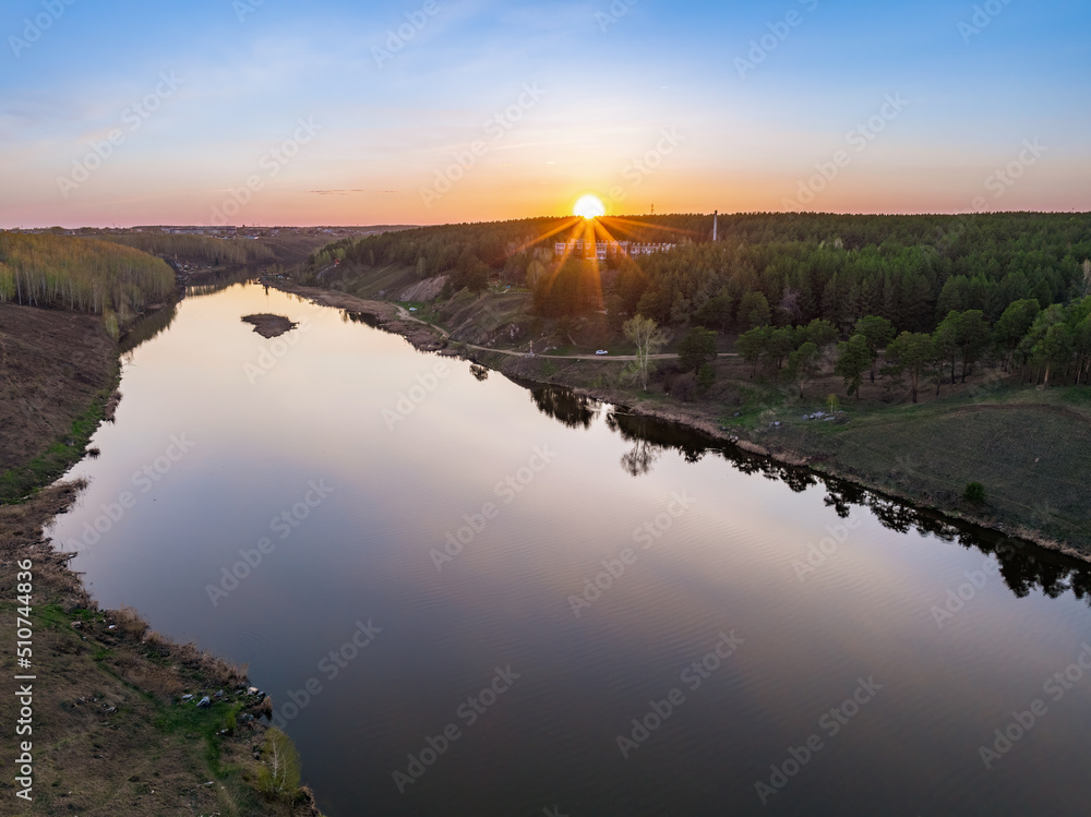 Beauriful sunset view along the Iset river and rocks near Kamensk-Uralskiy. A scenic sunset at the river. Kamensk-Uralskiy, Sverdlovsk region, Ural mountains, Russia. Aerial view