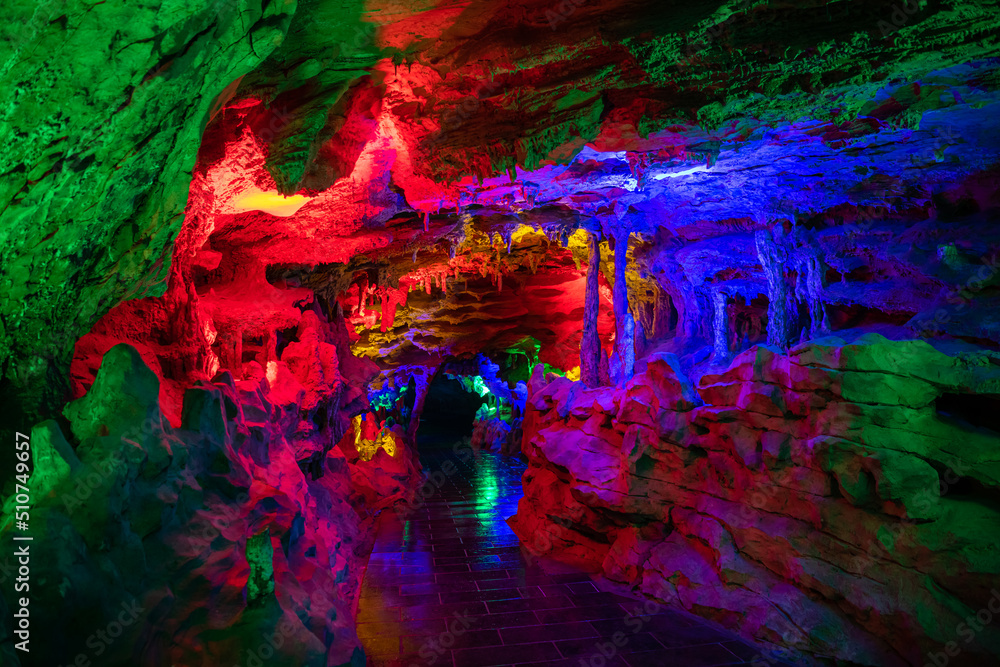 Horizontal background image of the dark blue, purple, green lighting of the Huanglong cave, Zhangjiajie, Hunan, China, copy space for text, background