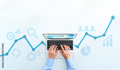 Web analytics and digital marketing. Top view of business man using laptop. Blue graphs and icons. photo