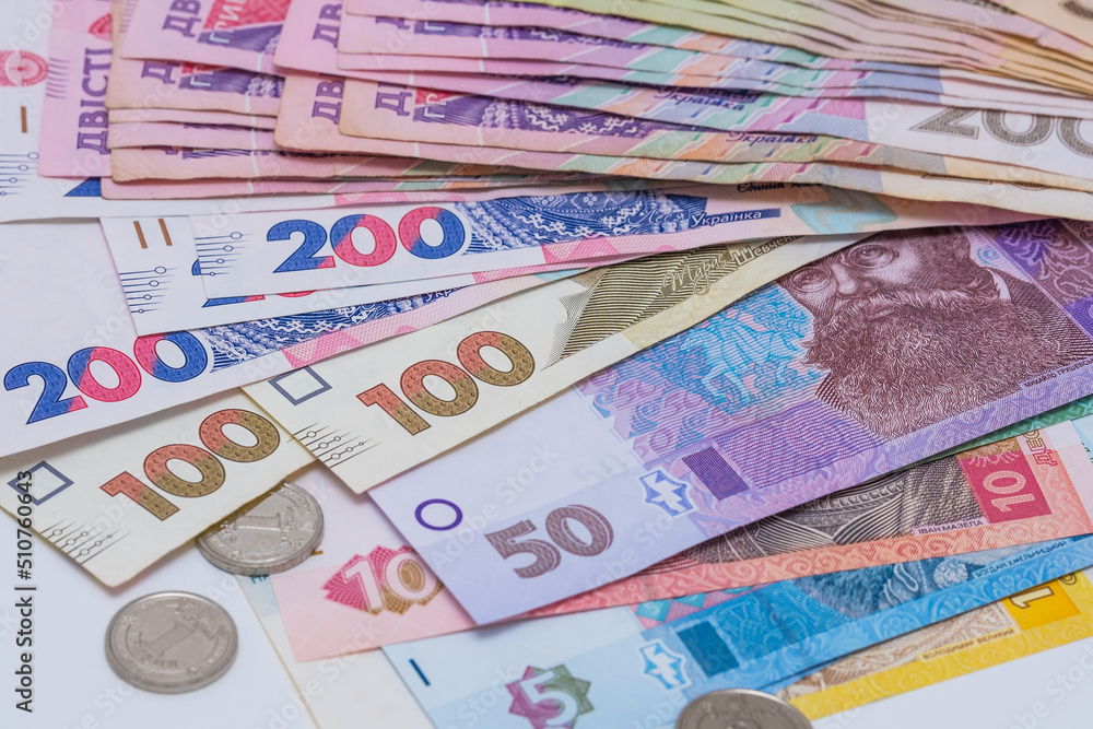 Obraz premium Ukrainian hryvnia and coins, background. Concept of receiving a salary, pension, inflation, deposit and credit. Concept of increasing the price of utilities, energy, gast