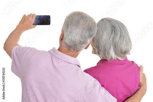 Portrait of a happy senior couple taking selfie photo at white background