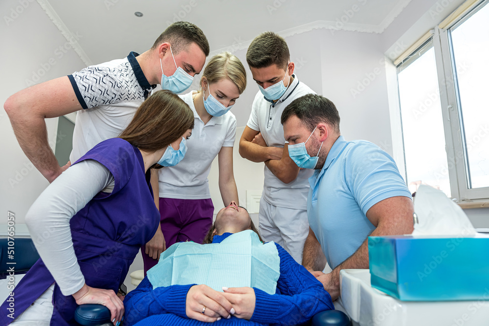 A cheerful group of dentists and their assistants stand in the dental office and smile happily. A cheerful group of dentists and their assistants stand in the dental office and smile happily.