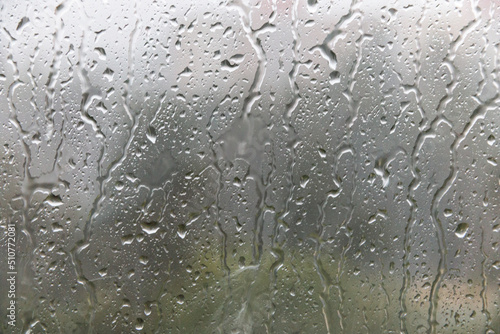 Raindrops run down the window pane. Rainy weather. Soft selective focus.