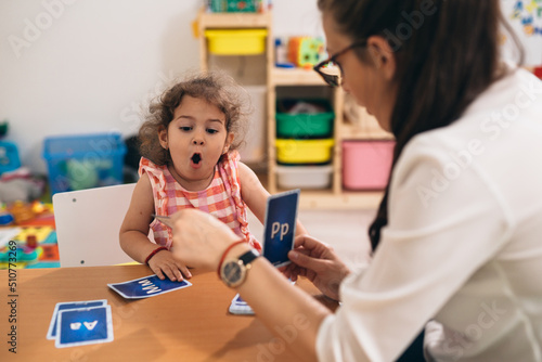 Photos psychologist having speech support session with young girl in kindergarden