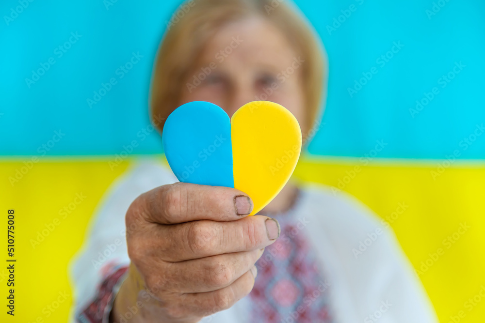 Grandmother is a Ukrainian patriot in an embroidered shirt. selective focus. Grandmother is a Ukrainian patriot in an embroidered shirt. selective focus.
