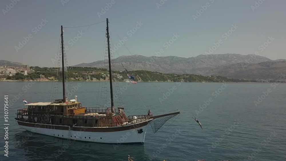 Slow motion: Tourist dives off bowsprit of Croatian tour ship into sea Slow motion: Tourist dives off bowsprit of Croatian tour ship into sea